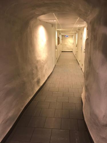 an empty hallway in a building with a tunnel at Hostel Dalagatan in Stockholm