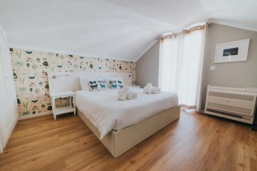 フンシャルにあるMansarda dos Aranhas by Madeira Best Apartmentsのウッドフロアのベッドルーム1室(大きな白いベッド1台付)