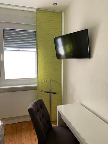 a room with a table and a tv on a wall at Die Weinsiedelei in Löhne