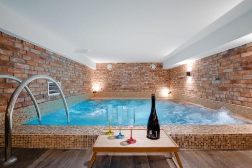 a hot tub with a bottle of wine and wine glasses at Plaża Resort in Bogaczewo