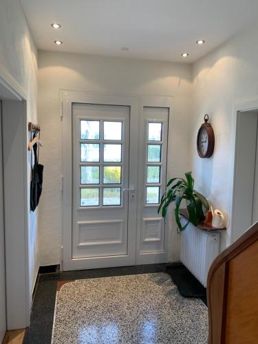 a hallway with a white door and a plant at Die Weinsiedelei in Löhne