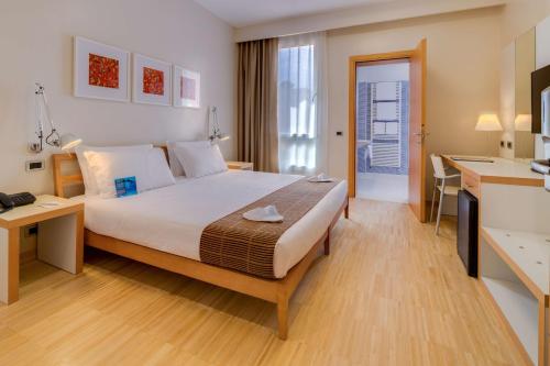 a hotel room with a large bed and a desk at Best Western Plus Hotel Bologna in Mestre