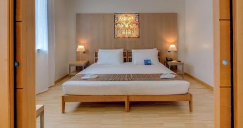 a bedroom with a large white bed with two tables at Best Western Plus Hotel Bologna in Mestre