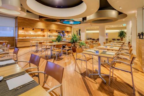 a restaurant with wooden floors and tables and chairs at Best Western Plus Hotel Bologna in Mestre