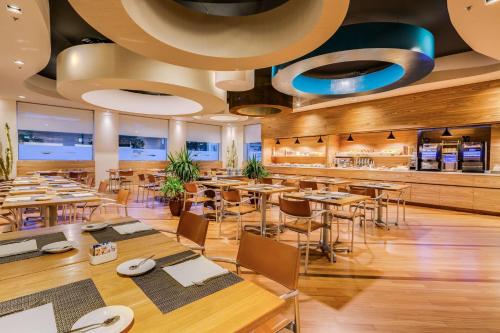 a restaurant with tables and chairs and a bar at Best Western Plus Hotel Bologna in Mestre