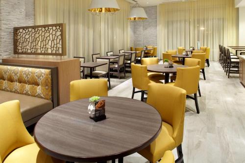 a dining room with tables and yellow chairs at Hyatt Place Miami Airport East in Miami