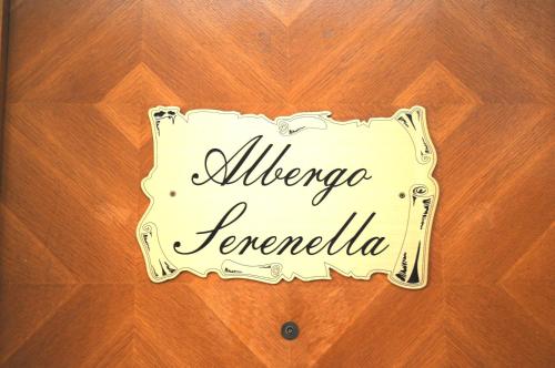 a sign that reads albuquerque temoria on a wooden table at Hotel Serenella in Turin