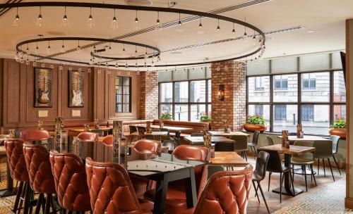 a restaurant with leather chairs and tables and windows at Hard Rock Hotel Dublin in Dublin
