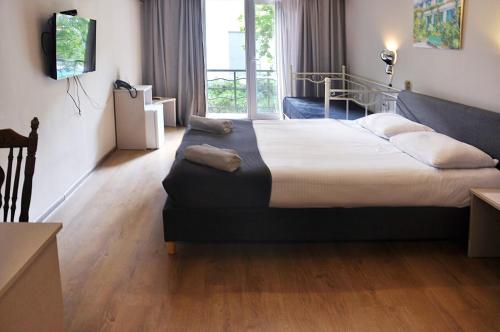 a hotel room with a large bed and a window at Art Hotel Claude Monet in Tbilisi City