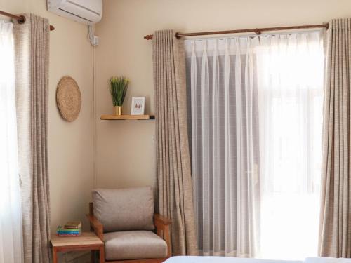 a bedroom with a chair and a window at Kibu Home in Kathmandu