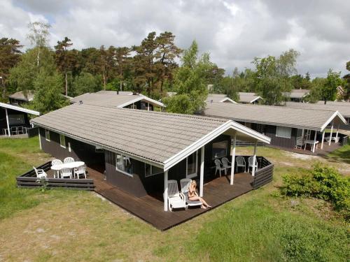 a house with a deck with chairs on it at Cozy Holiday Home in Nexo with Sauna in Snogebæk