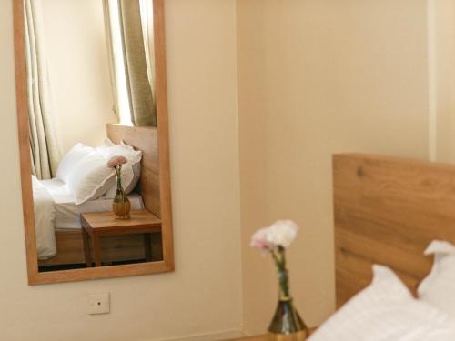 a bedroom with a mirror and a bed with flowers at Kibu Home in Kathmandu