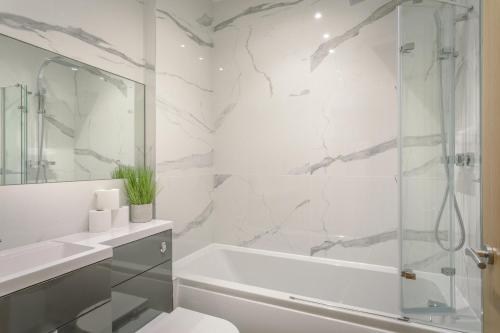 y baño con ducha, aseo y bañera. en Stylish & Modern: Central Hitchin - with Parking, en Hitchin