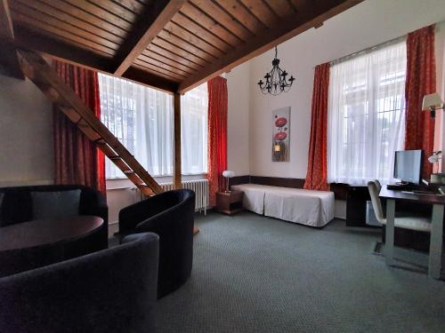 a hotel room with a bed and a desk and windows at Pension Jana - Domov Mládeže in Prague