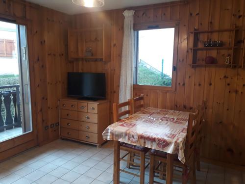 a dining room with a table and a television at OURSONS 1 in Morillon