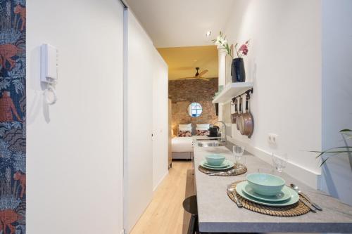 une cuisine avec des murs blancs et un comptoir avec des assiettes. dans l'établissement The Red Monkey, à Anvers