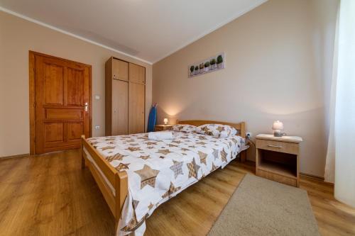 1 dormitorio con 1 cama grande y puerta de madera en Apartments Pelle, en Tivat