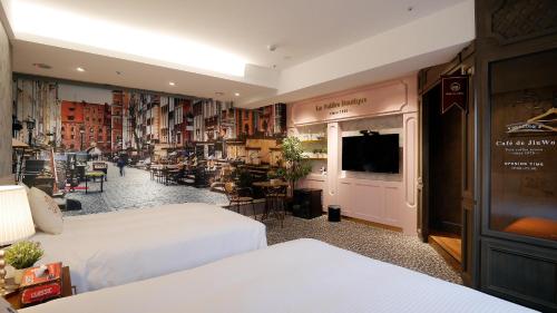a hotel room with two beds and a television at K Hotel - Yizhong in Taichung