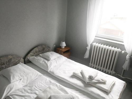 an unmade bed in a bedroom with a window at Tompos Vendégház és pince in Villány