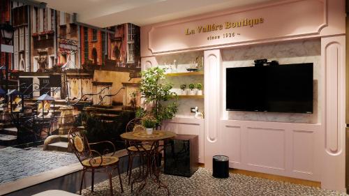 a living room with a tv on a wall at K Hotel - Yizhong in Taichung