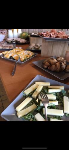 a plate of cheese and vegetables on a table at Hotel Restaurant Rothorn in Visperterminen