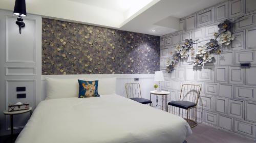 a bedroom with a white bed and two chairs at K Hotel - Yizhong in Taichung