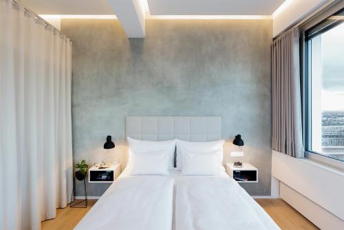 1 dormitorio con cama blanca y ventana grande en PhilsPlace Full-Service Apartments Vienna, en Viena