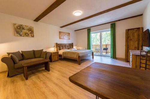 duży salon z łóżkiem i kanapą w obiekcie Apartment Marie w mieście Lipno nad Vltavou