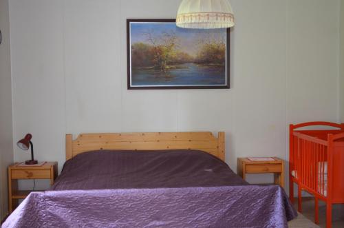 una camera da letto con un letto e un quadro sul muro di Sänkelä Cottage a Lämsä