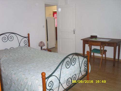 um quarto com uma cama, uma mesa e uma secretária em Maison - Chambre d’hôte située au cœur d Asfeld em Asfeld