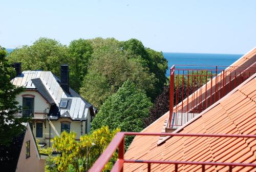 a house sitting on top of a hill next to the ocean at Sköna Hönor Apartments in Visby