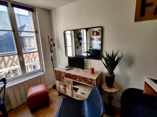 Cette chambre comprend un miroir et un bureau avec une chaise. dans l'établissement Escapade à Honfleur, à Honfleur