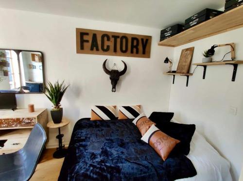 - une chambre avec un lit et un panneau indiquant l'usine dans l'établissement Escapade à Honfleur, à Honfleur