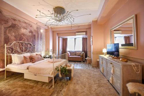 a bedroom with a bed and a tv and a mirror at PURRFECT & DREAMY - The Special Studio in Bucharest