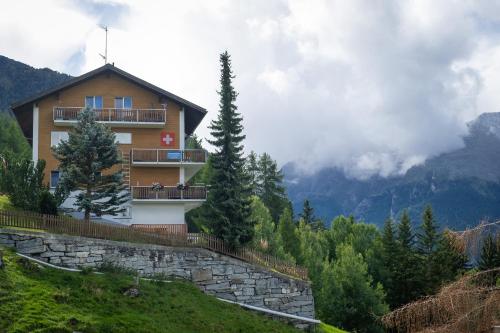 a house on the side of a hill with mountains at Panorama at Haus Waldheim Nr. 11 in Grächen