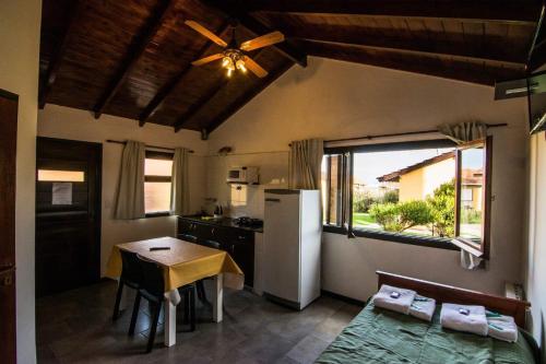 a kitchen with a small table and a refrigerator at Complejo San Cristobal in Santa Clara del Mar