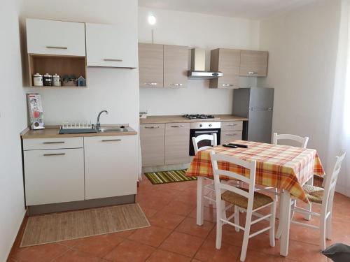 a kitchen with a table and a kitchen with white cabinets at CASAWHITE in Cavallino-Treporti