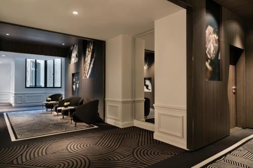 a lobby with a waiting area with chairs and a mirror at La Clef Champs-Élysées Paris by The Crest Collection in Paris