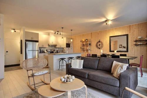 a living room with a couch and a kitchen at The Shack by BnbCopilote in Quebec City