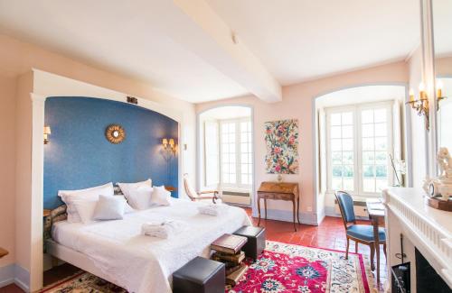 een slaapkamer met een groot bed met een blauwe muur bij Manoir De Ponsay in Chantonnay