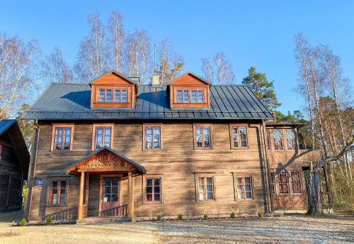 a large wooden house with a black roof at Villa Gaida in Saulkrasti