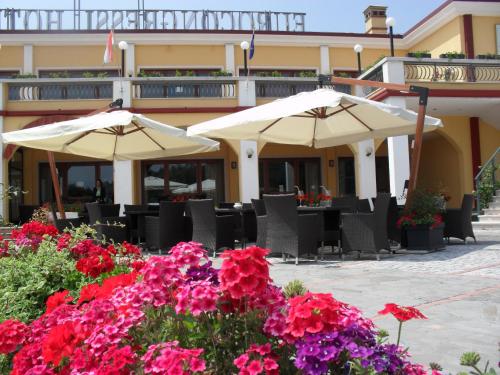 two umbrellas and flowers in front of a hotel at Eurocongressi Hotel in Cavaion Veronese