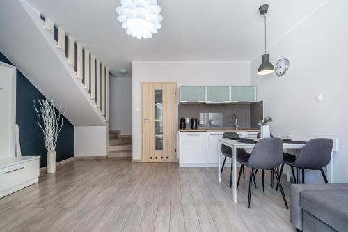 a kitchen and living room with a table and chairs at Apartamenty Hallerowo in Władysławowo