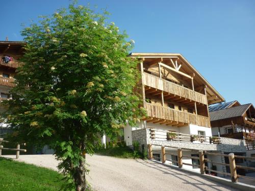 un grande edificio con un albero di fronte di Chalet Apartments Ambria a La Villa