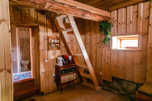 Habitación pequeña con escalera en una cabaña en Rosma Mill Holiday House, en Põlva