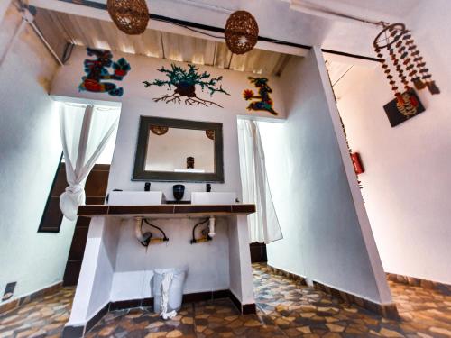 Zimmer mit Waschbecken und Spiegel an der Wand in der Unterkunft MahaSand Hotel & Hostel in Mahahual