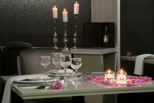 a table with wine glasses and candles on it at Lancaster House in Bogotá