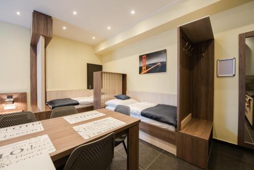 een kamer met een bed en een tafel en stoelen bij Apartments Danube in Bratislava
