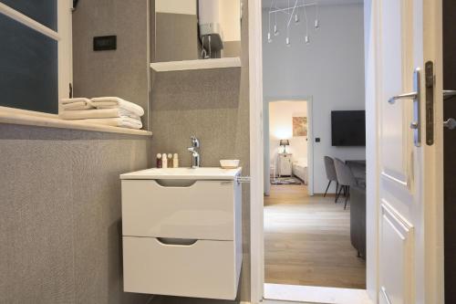 a bathroom with a white sink and a hallway at Palmotta Palace in Dubrovnik