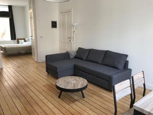 オーステンデにあるCamelias@sea - Appartementのリビングルーム(青いソファ、テーブル付)